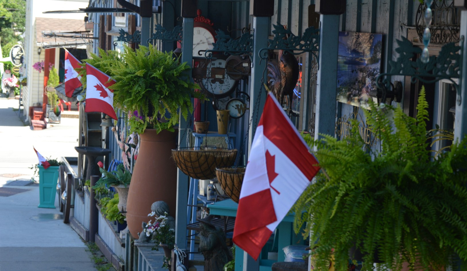 Canadian flags waving from pillars in a storefront.