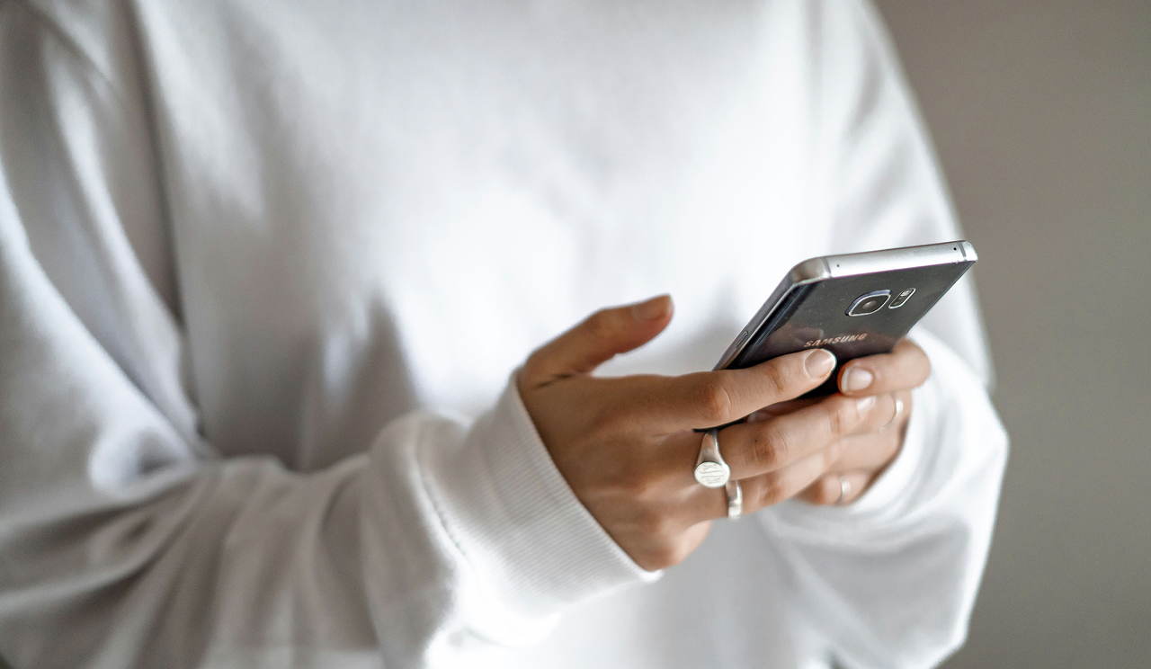 A person holding a cellphone in their hands.